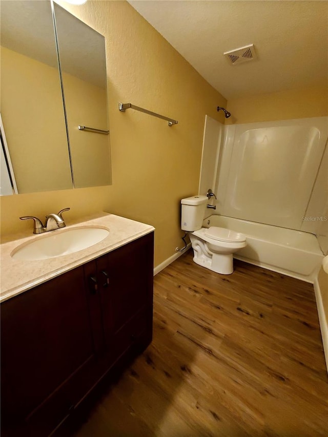 full bathroom featuring wood-type flooring, toilet, shower / washtub combination, and vanity