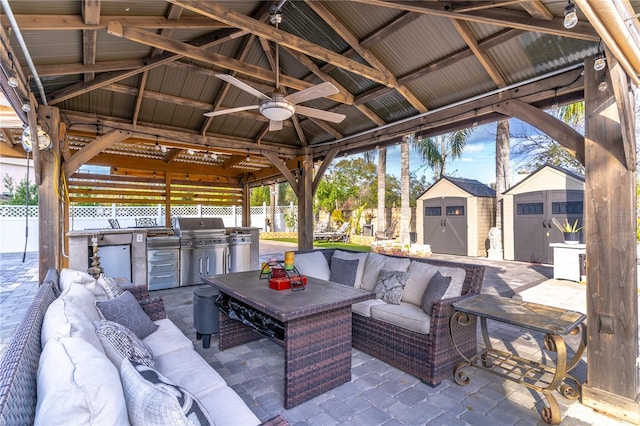 view of patio / terrace featuring a storage shed, a gazebo, outdoor lounge area, and an outdoor kitchen