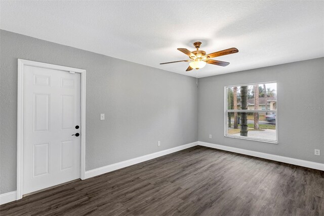 empty room with ceiling fan, dark hardwood / wood-style floors, and a textured ceiling