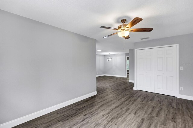 empty room with dark wood-type flooring, a textured ceiling, and ceiling fan