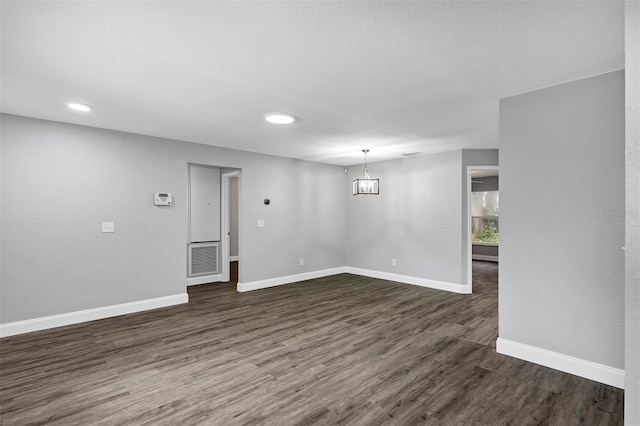 interior space with an inviting chandelier, dark hardwood / wood-style floors, and a textured ceiling