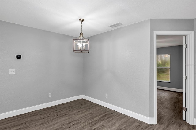 unfurnished dining area with dark hardwood / wood-style flooring and a notable chandelier