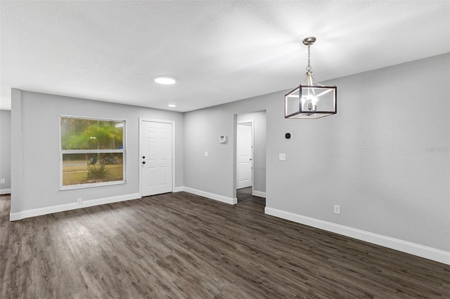 interior space featuring dark hardwood / wood-style floors and an inviting chandelier