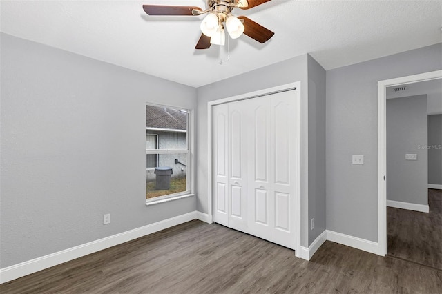 unfurnished bedroom with ceiling fan, wood-type flooring, and a closet