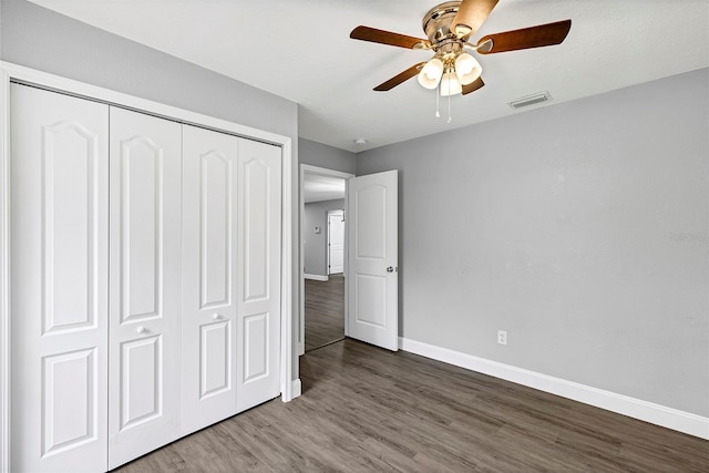 unfurnished bedroom with wood-type flooring, ceiling fan, and a closet