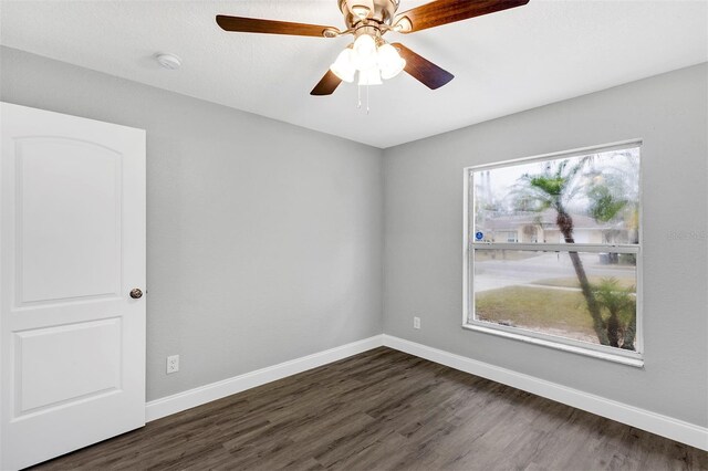 empty room featuring ceiling fan and dark hardwood / wood-style flooring