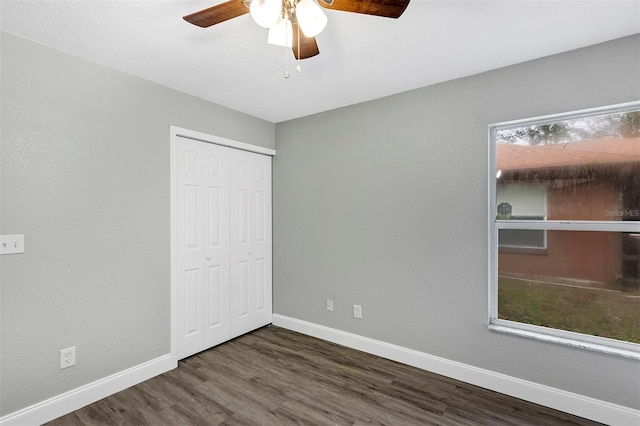 unfurnished bedroom featuring dark hardwood / wood-style flooring, a closet, and ceiling fan