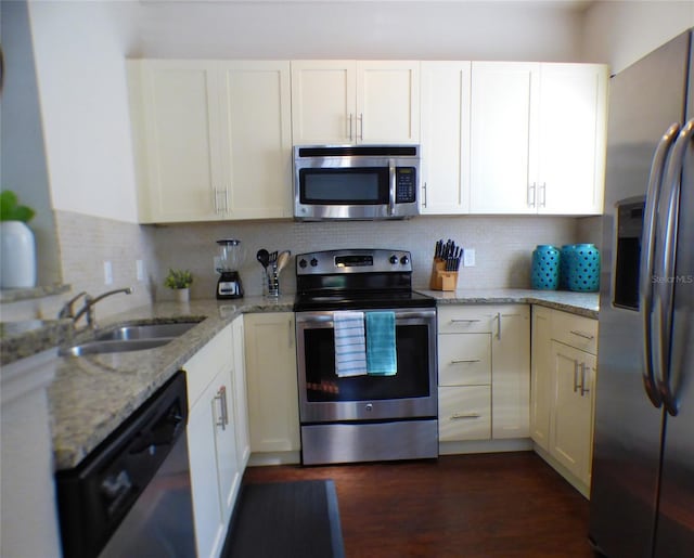 kitchen with white cabinetry, appliances with stainless steel finishes, sink, and light stone counters