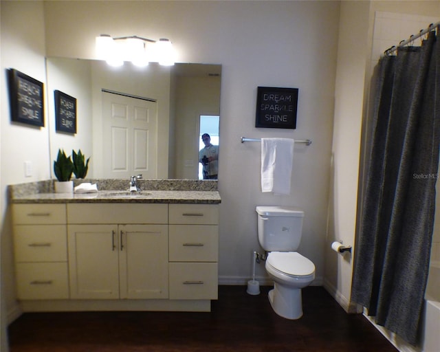 full bathroom with vanity, toilet, wood-type flooring, and shower / bath combo