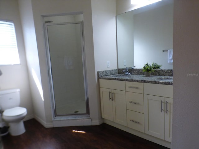 bathroom with a shower with door, vanity, hardwood / wood-style flooring, and toilet