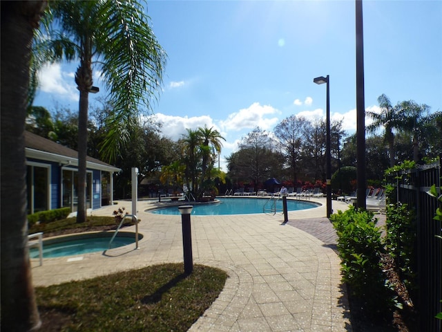 view of swimming pool featuring a community hot tub and a patio area