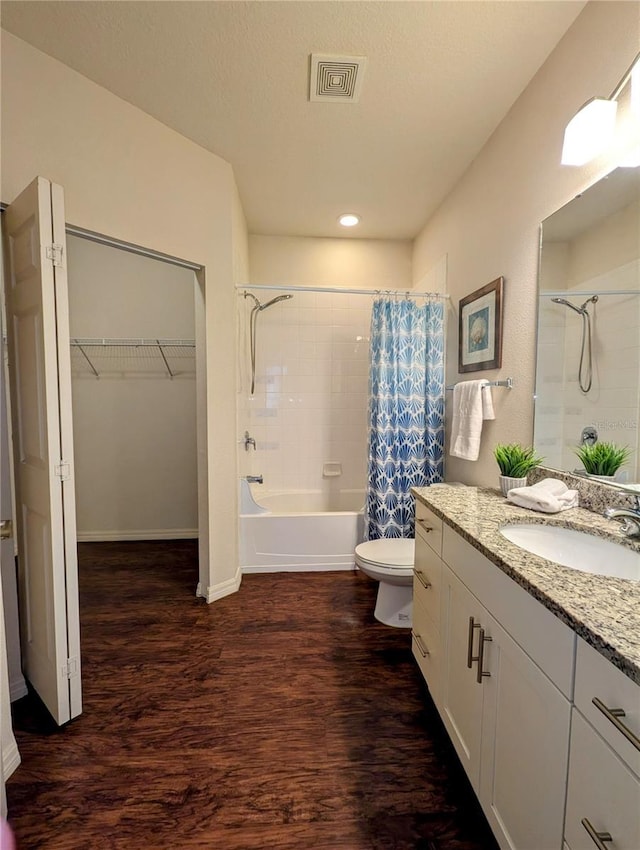 bathroom with toilet, wood finished floors, visible vents, vanity, and shower / bath combination with curtain