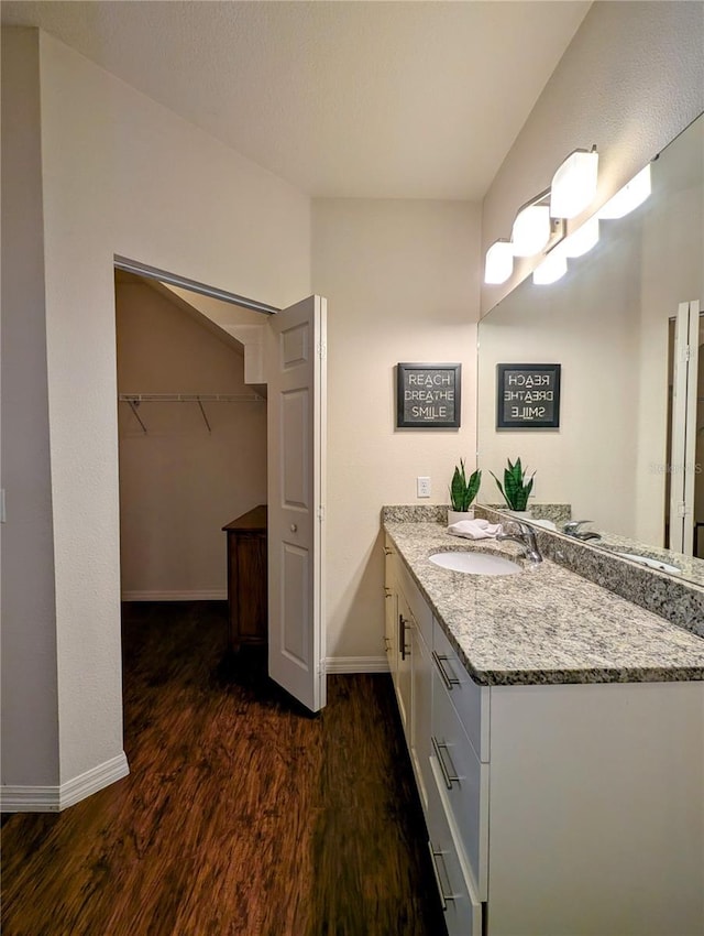 bathroom featuring wood finished floors, vanity, and baseboards