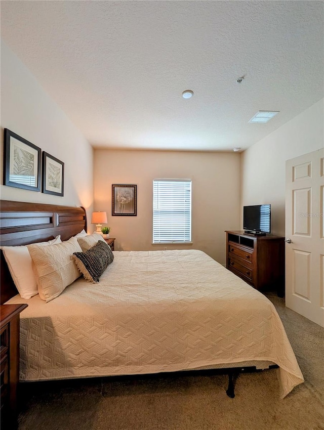 bedroom with carpet and a textured ceiling