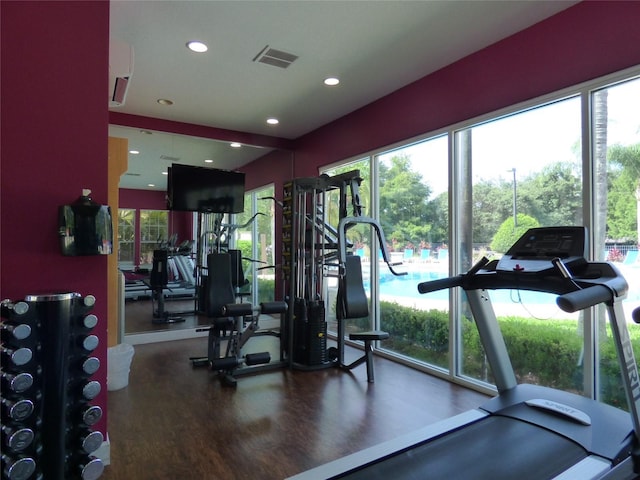 gym with recessed lighting, visible vents, plenty of natural light, and wood finished floors