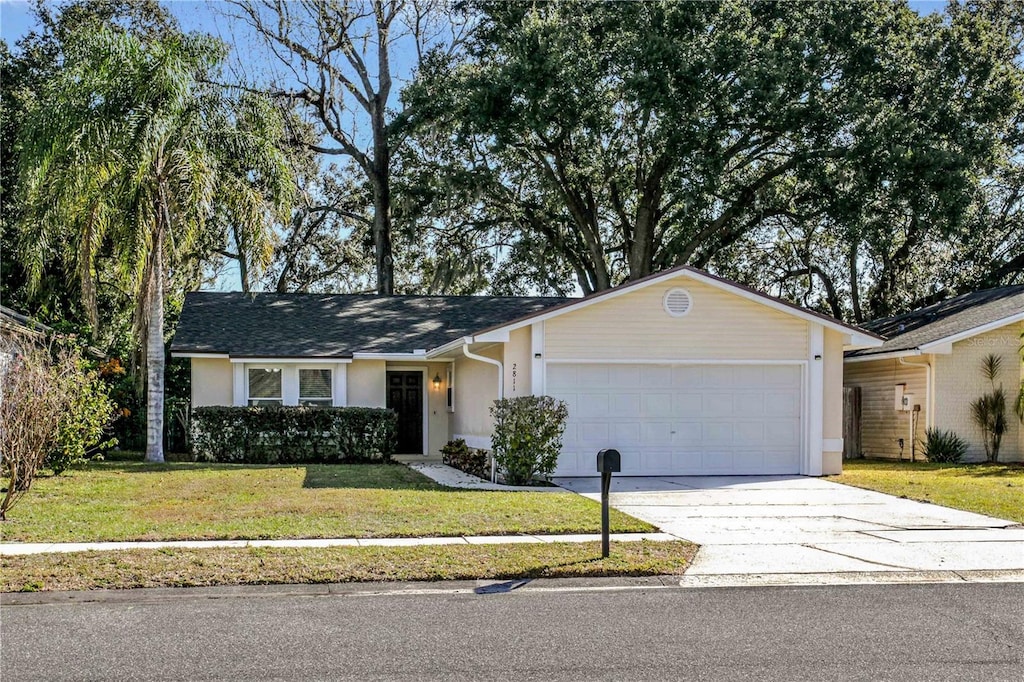 single story home featuring a garage and a front lawn