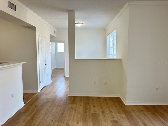 unfurnished room with ornamental molding and light hardwood / wood-style floors