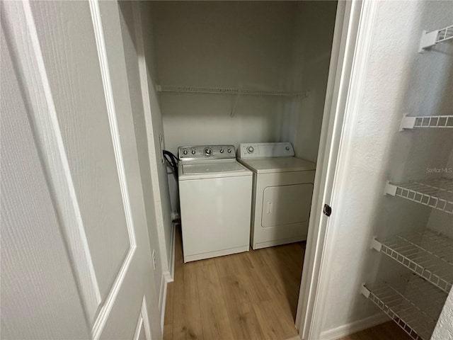 laundry room featuring washer and dryer and light hardwood / wood-style flooring