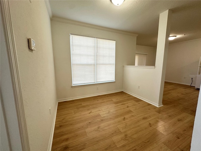 unfurnished room featuring crown molding and light hardwood / wood-style flooring