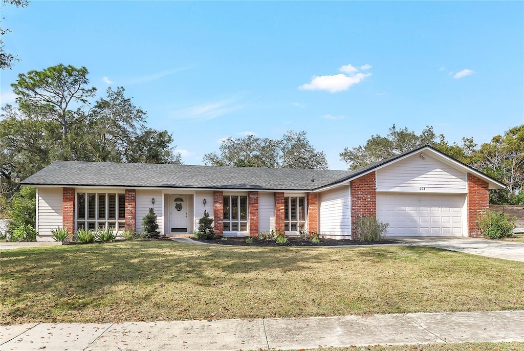 ranch-style house featuring a garage and a front lawn