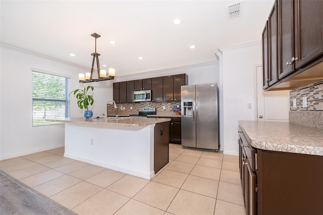 kitchen featuring sink, appliances with stainless steel finishes, decorative light fixtures, and a kitchen island with sink