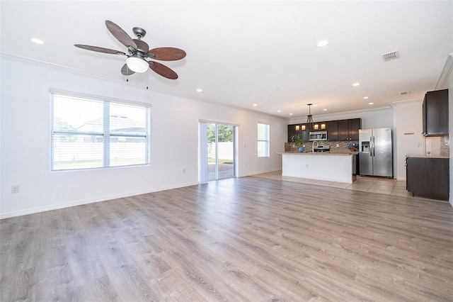 unfurnished living room featuring crown molding, light hardwood / wood-style floors, and ceiling fan