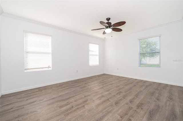 empty room with hardwood / wood-style flooring, plenty of natural light, ornamental molding, and ceiling fan