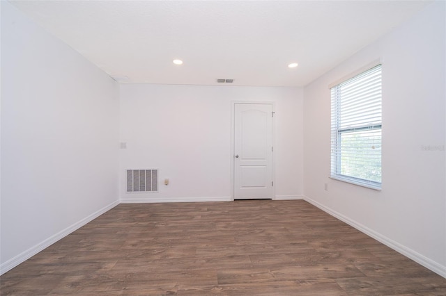 unfurnished room with dark wood-type flooring