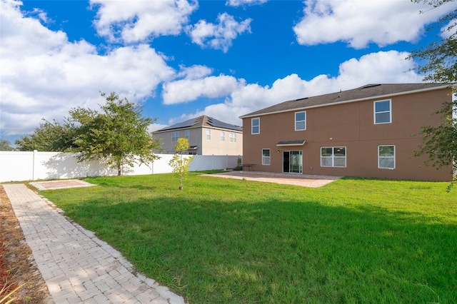 rear view of property with a yard and a patio