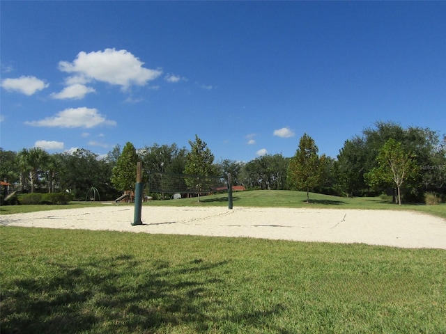 view of property's community featuring a lawn and volleyball court