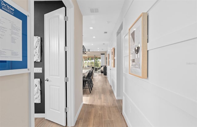 corridor with light hardwood / wood-style floors