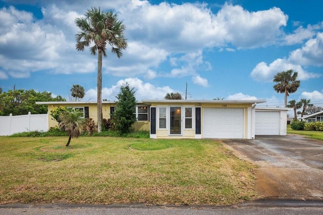 ranch-style house with a garage, driveway, a front lawn, and fence