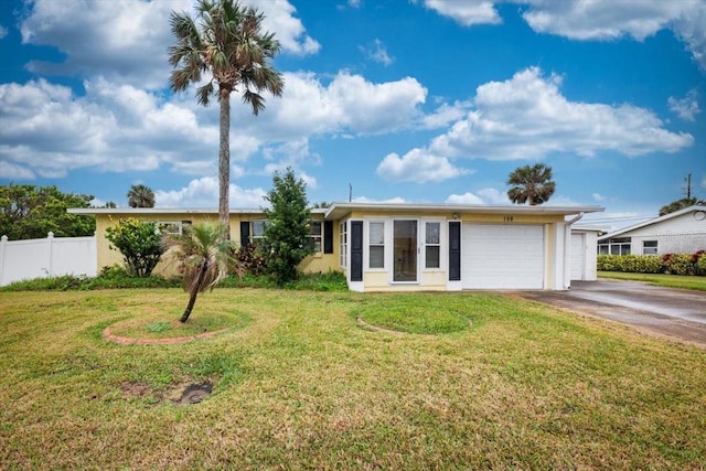 ranch-style home featuring a garage, driveway, a front yard, and fence