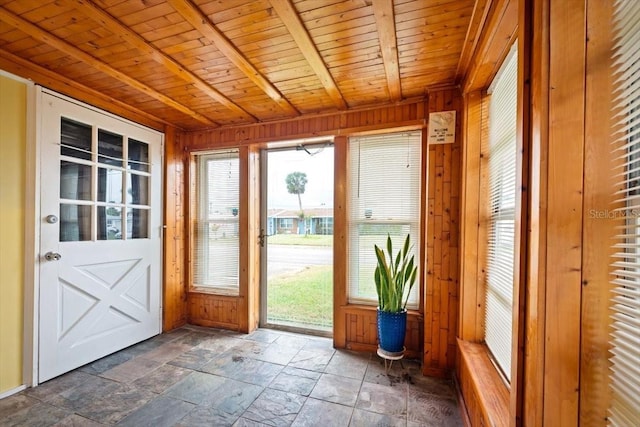 unfurnished sunroom featuring wooden ceiling and beam ceiling