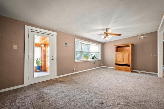 empty room featuring carpet floors, visible vents, baseboards, and a ceiling fan