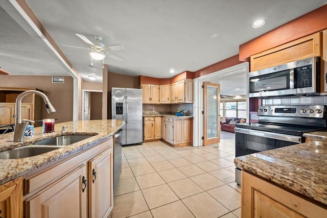 kitchen featuring light tile patterned floors, appliances with stainless steel finishes, a ceiling fan, light brown cabinets, and a sink