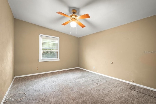 empty room with ceiling fan, carpet flooring, and baseboards