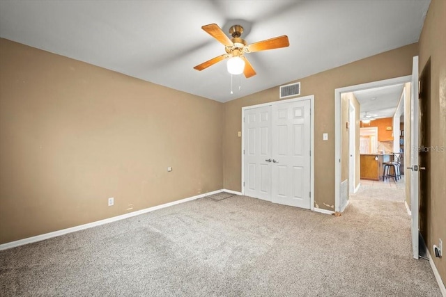 unfurnished bedroom featuring carpet, a closet, visible vents, ceiling fan, and baseboards