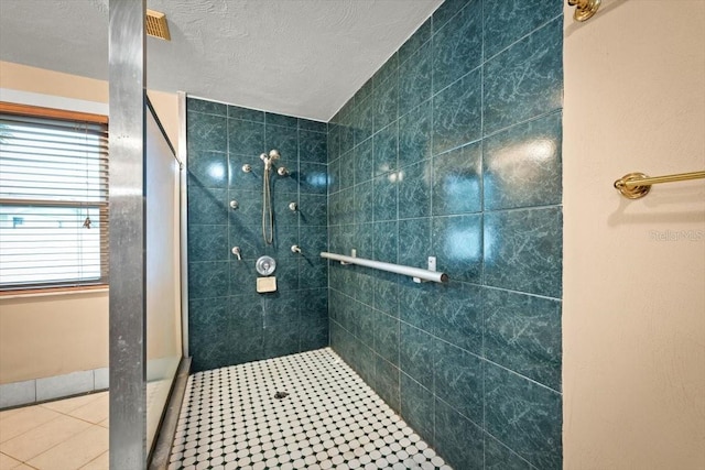 full bathroom featuring a textured ceiling and a tile shower