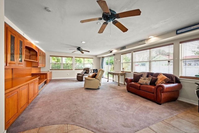 living room with baseboards, light tile patterned floors, and light colored carpet