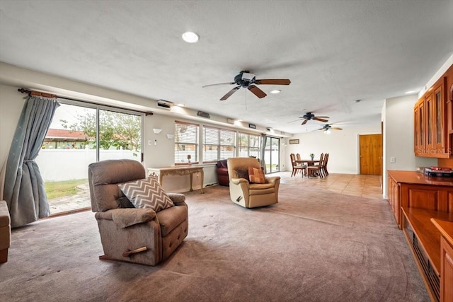 carpeted living room featuring a textured ceiling and ceiling fan