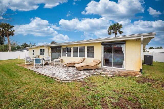 back of house featuring a patio, central air condition unit, fence, a yard, and stucco siding