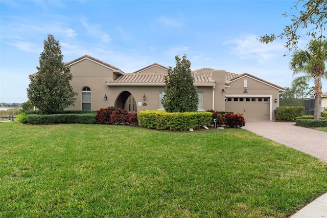 mediterranean / spanish-style house with a garage and a front yard