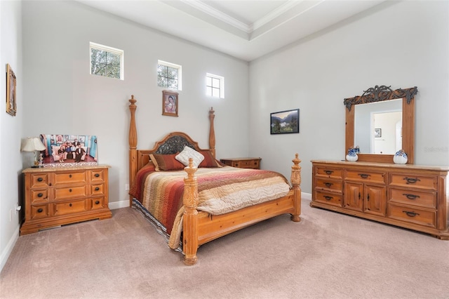 bedroom with crown molding, light carpet, and a tray ceiling