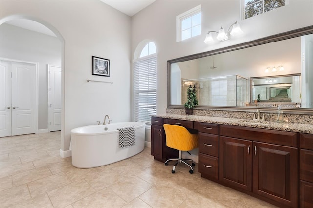 bathroom with vanity, a towering ceiling, and plus walk in shower