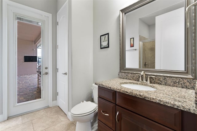 bathroom featuring tile patterned flooring, vanity, walk in shower, and toilet