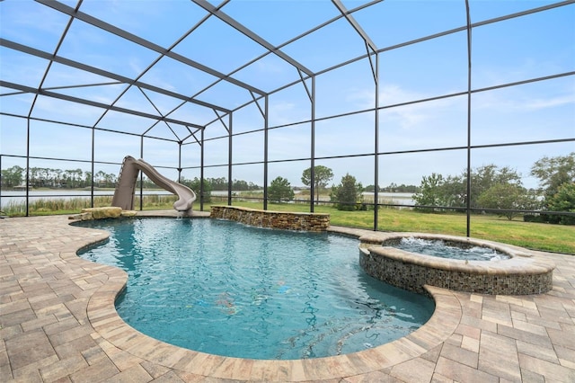 view of pool with an in ground hot tub, a patio, a water slide, and glass enclosure