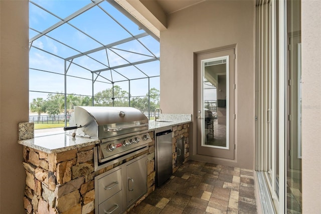 view of patio / terrace with area for grilling, sink, and a lanai