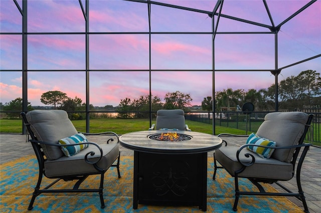 patio terrace at dusk featuring a yard and a fire pit