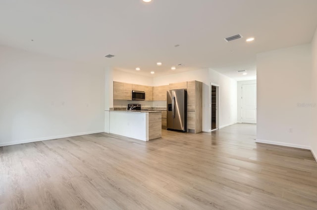 kitchen with open floor plan, appliances with stainless steel finishes, light wood-type flooring, a peninsula, and recessed lighting